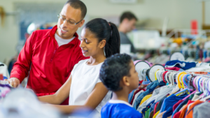 A family shown bargain hunting at a ReStore clothing section